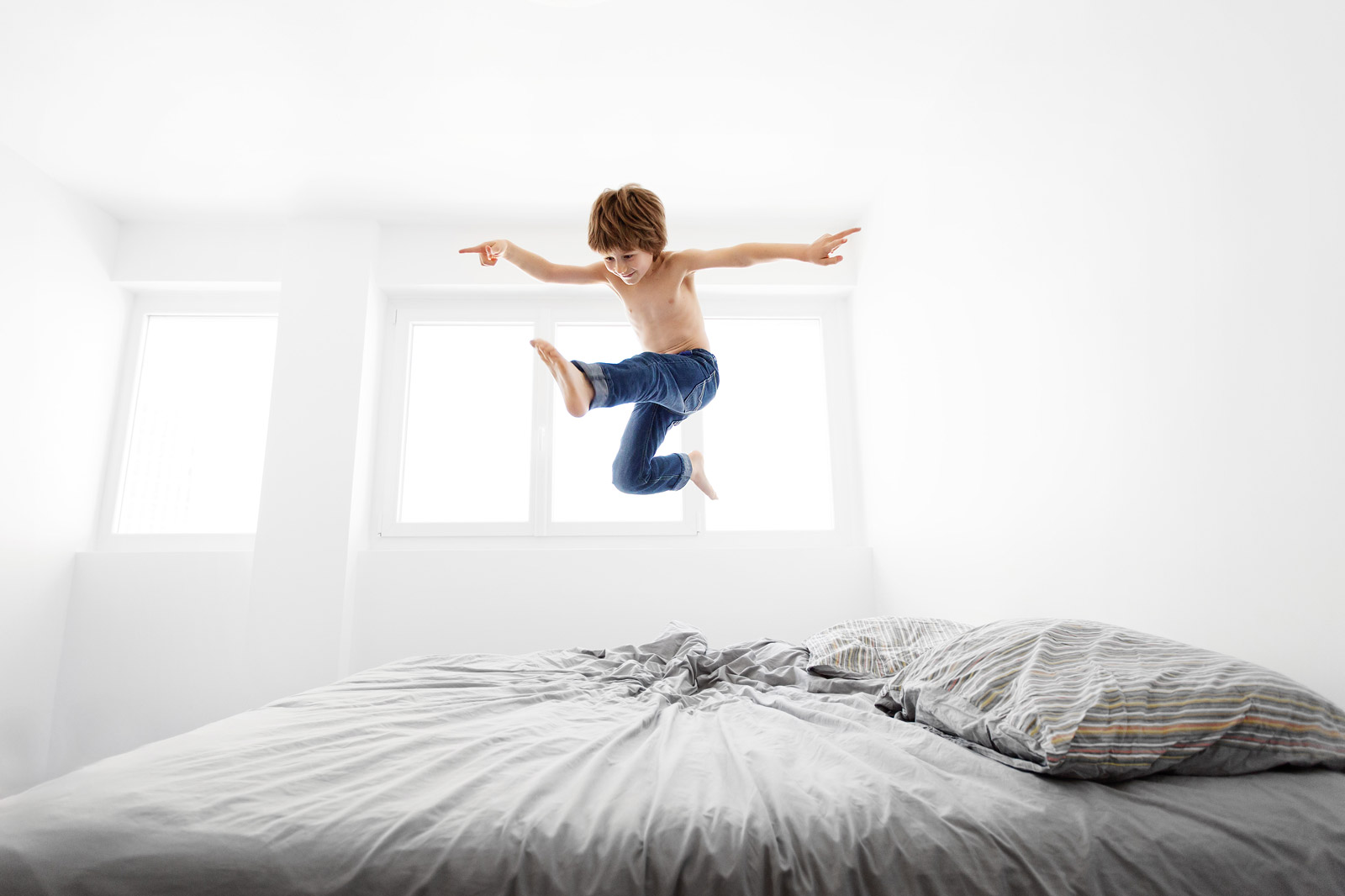 Boy jumping on bed